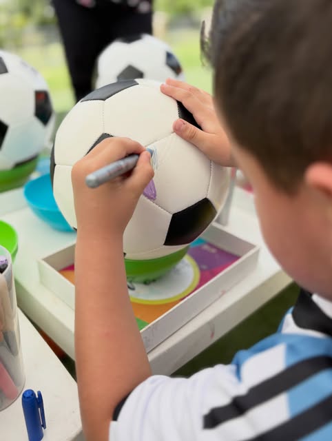 Niño personalizando un balón de fútbol en una actividad MORITA